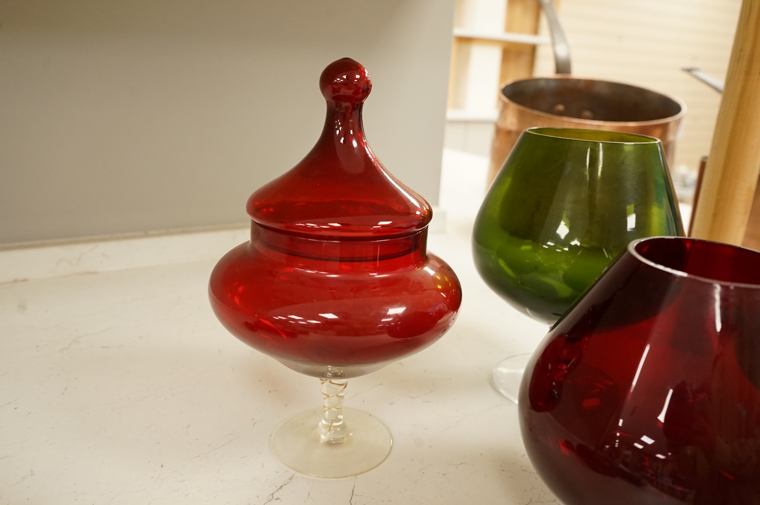 Five pieces of glassware to include a Swedish oversized brandy balloon, red glass sweetmeat dish and cover and a vase, largest 28cm high